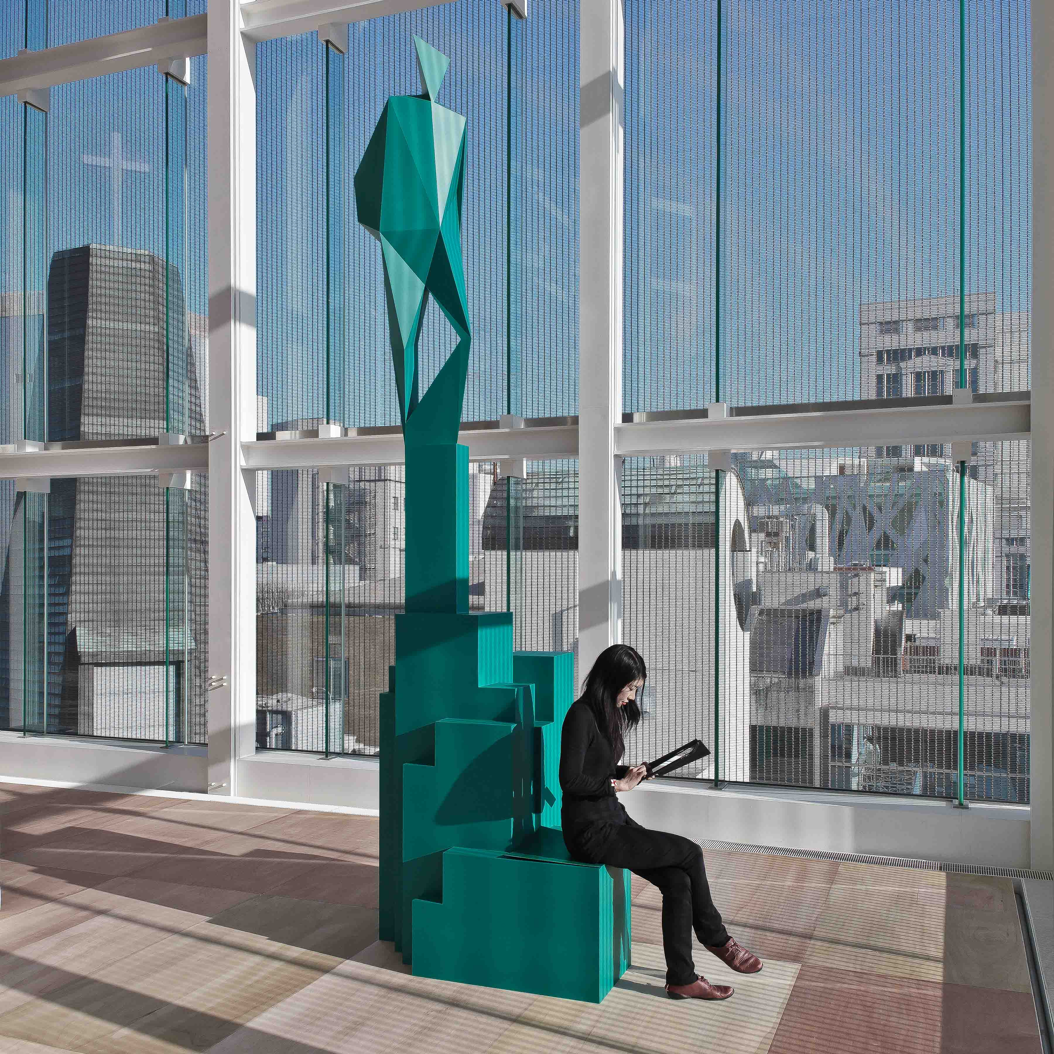 Visitor seated within Xavier Veilhan's green geometric sculpture