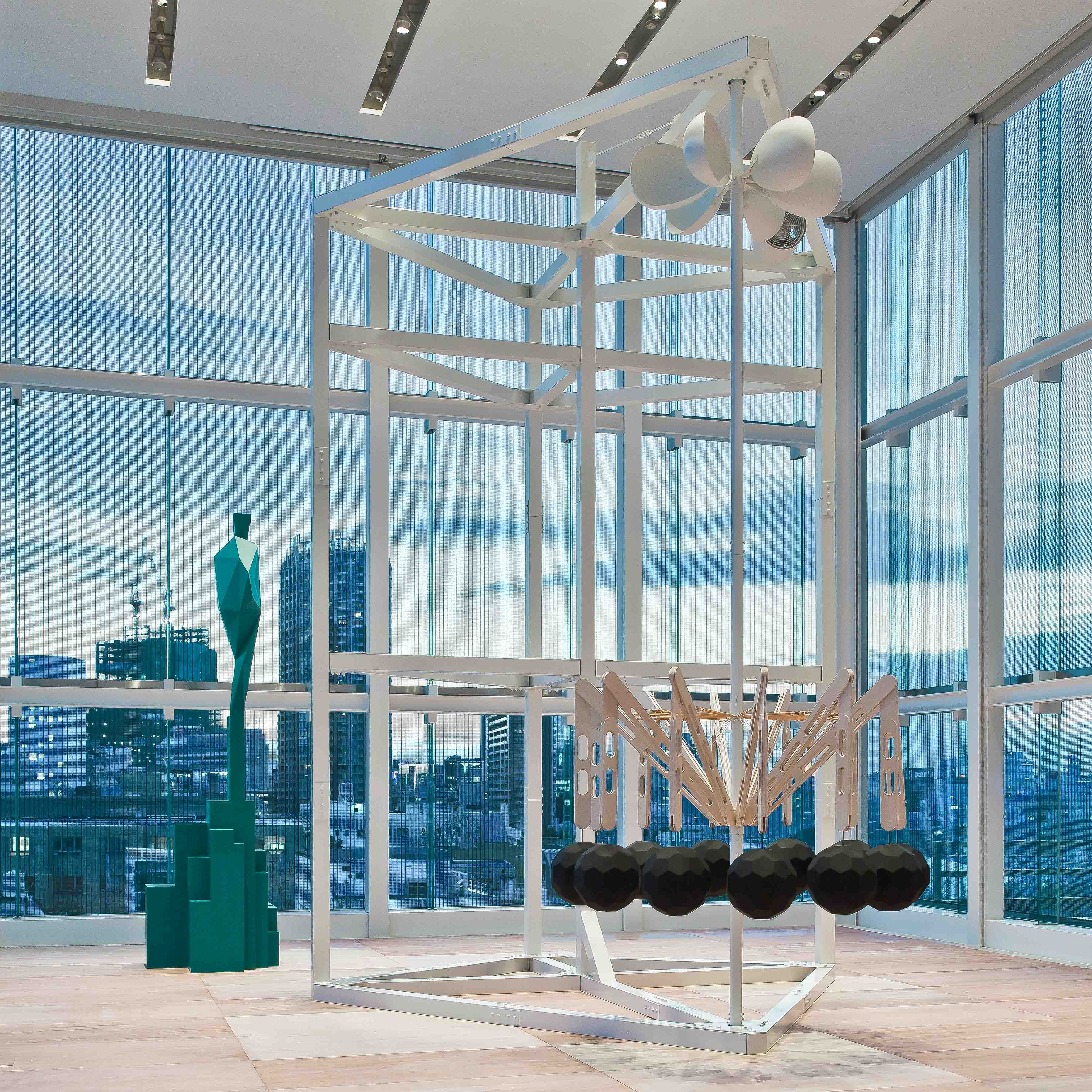 Free Fall installation framed by the glass architecture at dusk